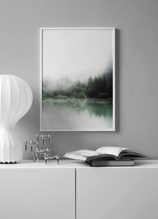  – Foto van een meer voor een bos met groene bomen die in het meer reflecteren