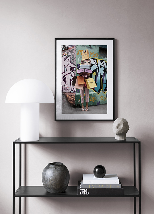  – Foto van een vrouw met schoenendozen en boodschappentassen voor een graffitimuur