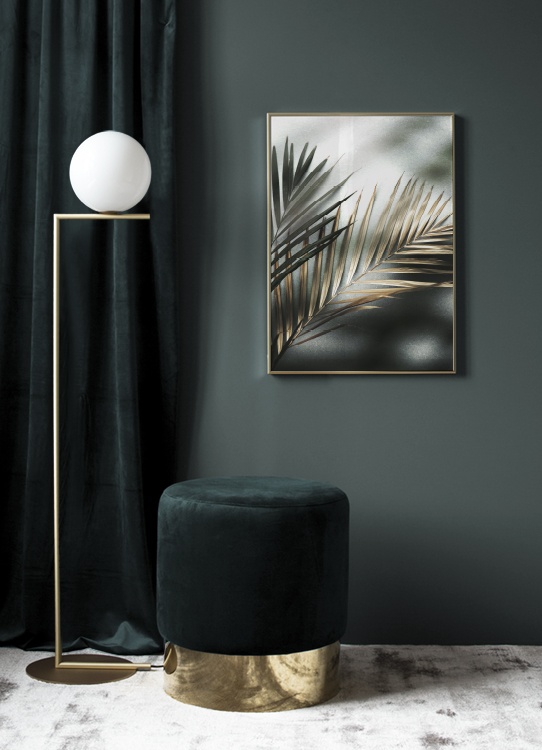  – Fotografie mit einem Paar Palmblättern in Gold und Grün vor einem Steinhintergrund