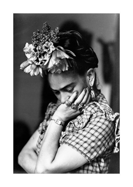  – Photographie en noir et blanc de Frida Kahlo avec des fleurs dans les cheveux et le menton dans sa main