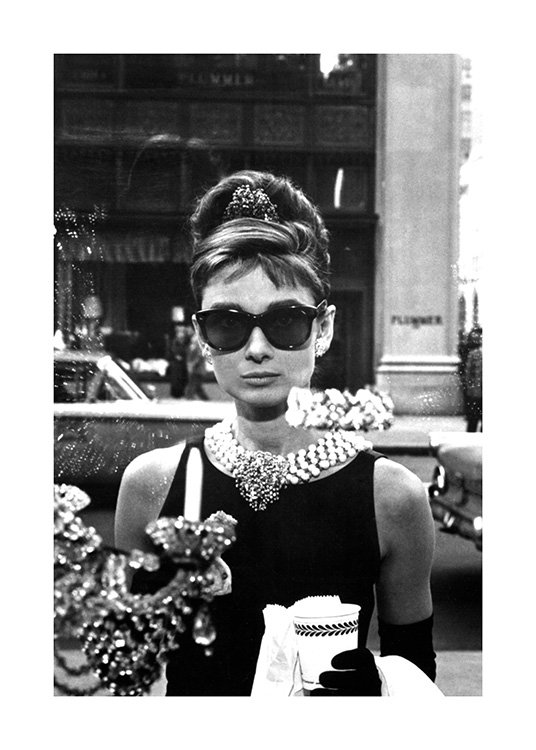  – Schwarz-weiß-Fotografie, die Audrey Hepburn in einer Sonnenbrille in dem Film „Frühstück bei Tiffany“ zeigt