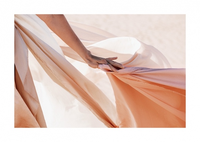  – Photographie d’un tissu transparent de couleur pêche tenu par une main de femme
