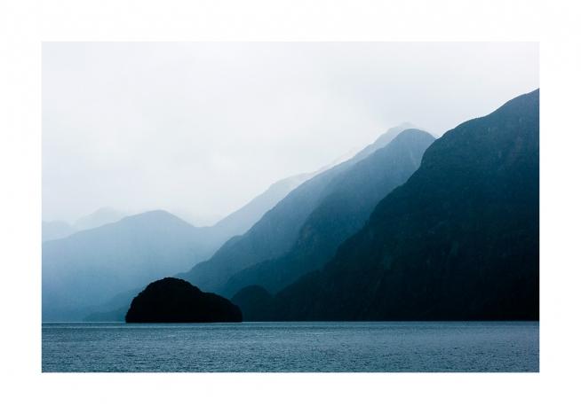  - Fotografie, die Meer vor blauen Bergen mit Nebelschichten dahinter zeigen