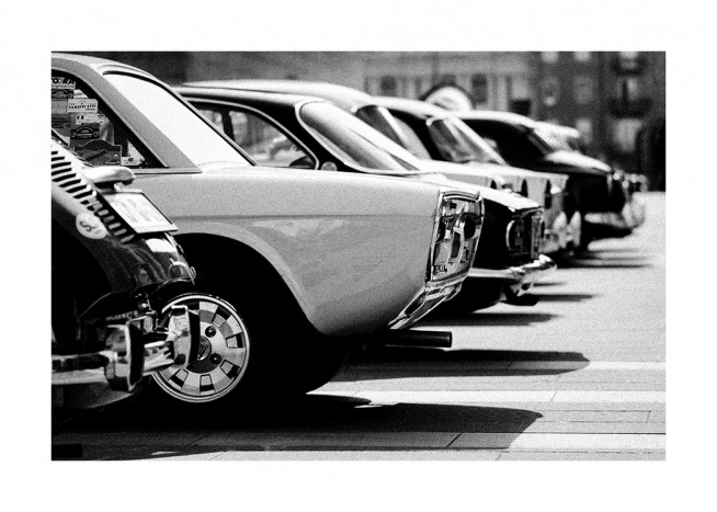  - Photographie en noir et blanc d'une ligne de voitures anciennes dans un parking