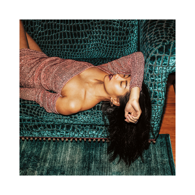 – Een foto van een vrouw in een sprankelende jurk die een dutje doet op een turquoise bank