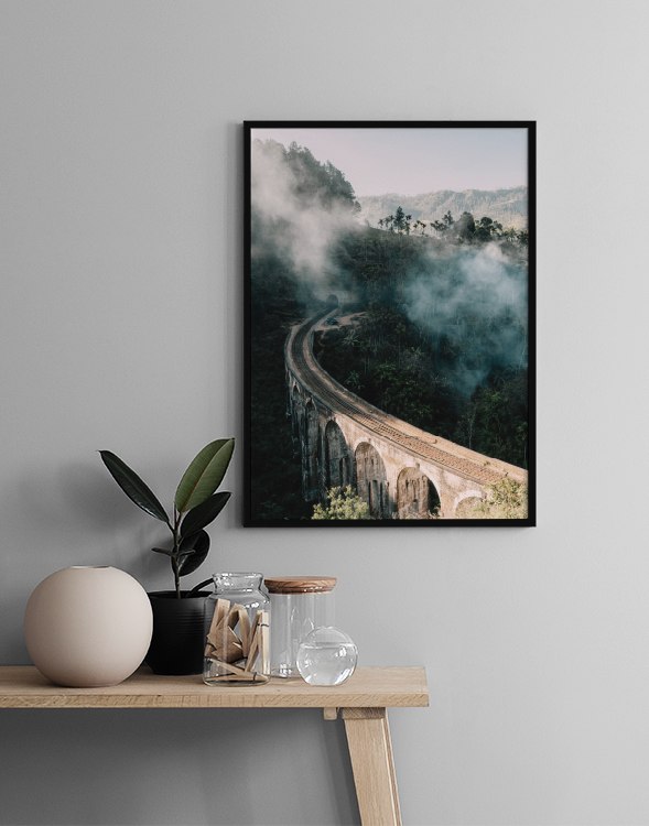  – Fotografie einer Brücke, die durch eine Landschaft mit Bäumen und Nebel führt